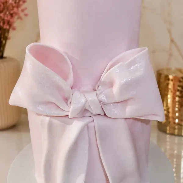 Bolo rosa com laço grande de pasta americana, feito pela Doces Luma Cakes