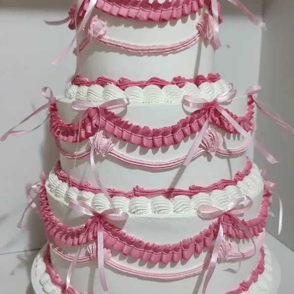 Bolo vintage de três andares branco e rosa com babados e laços de fita, feito pela Doces Luma Cakes